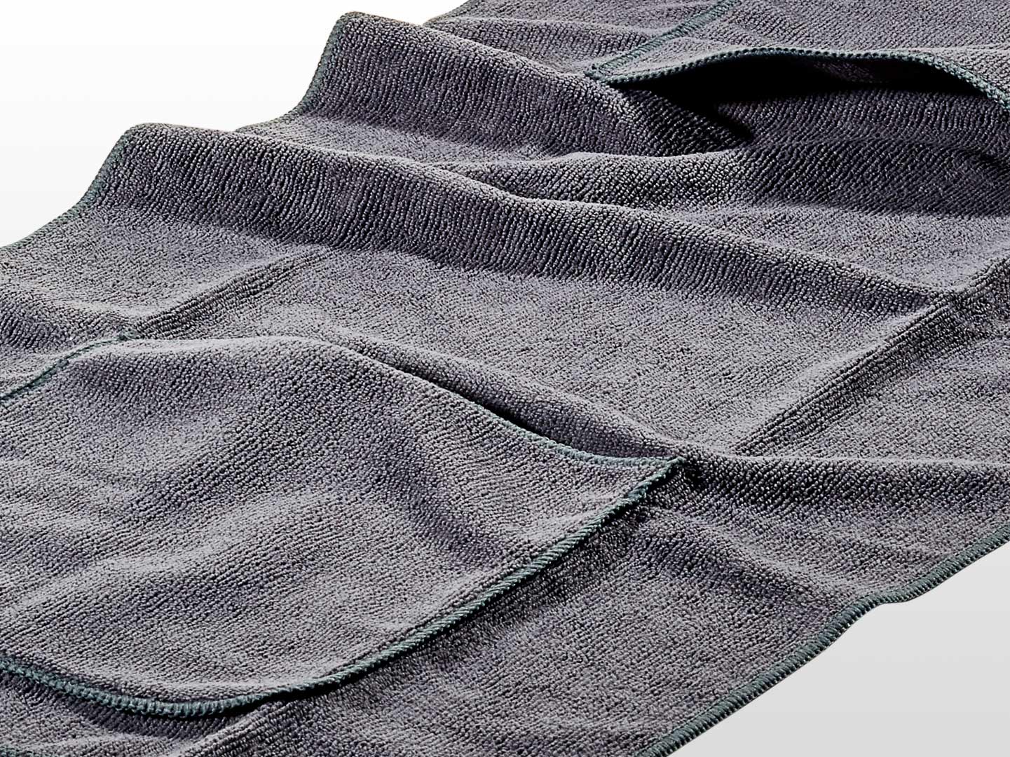 Eine Nahaufnahme des grauen, strukturierten Hunde-Handtuchs von Westerwald Beute (40 x 80 cm) zeigt die sauber abgesteppten Kanten, die sichtbaren Falten und die weiche Qualitätsverarbeitung der Marke Westerwald Beute.