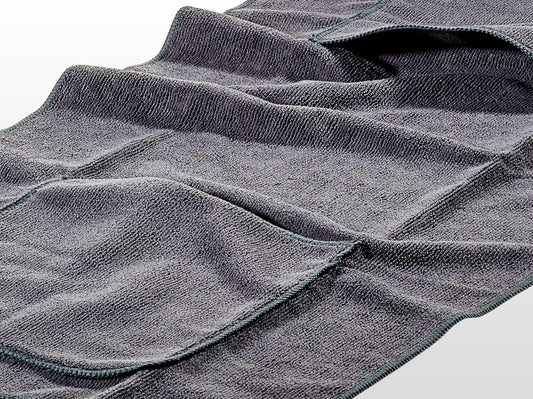 Eine Nahaufnahme des grauen, strukturierten Hunde-Handtuchs von Westerwald Beute (40 x 80 cm) zeigt die sauber abgesteppten Kanten, die sichtbaren Falten und die weiche Qualitätsverarbeitung der Marke Westerwald Beute.
